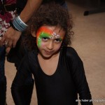 A kid wearing a black top with face paint