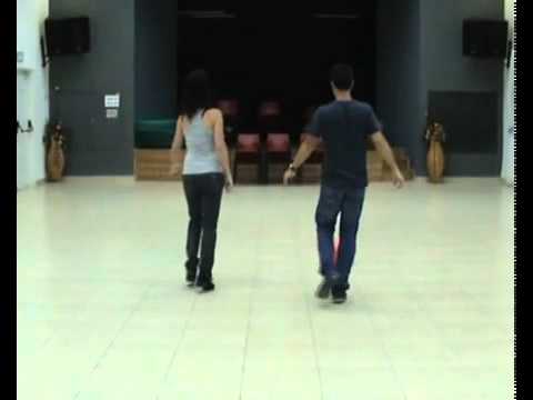 Two people are dancing in a room.